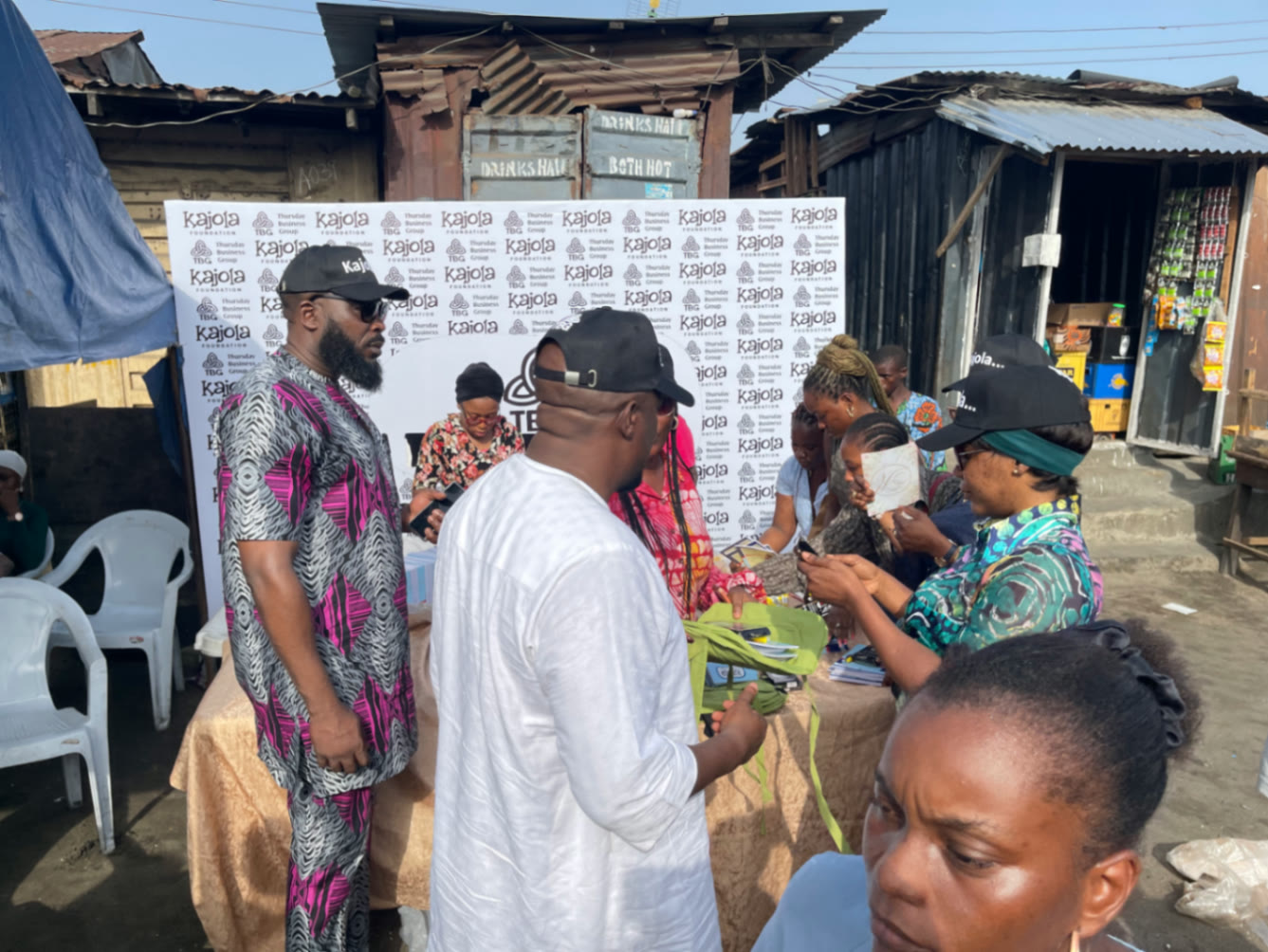 Kajola Foundation outreach table with volunteers distributing bags in a Lagos community