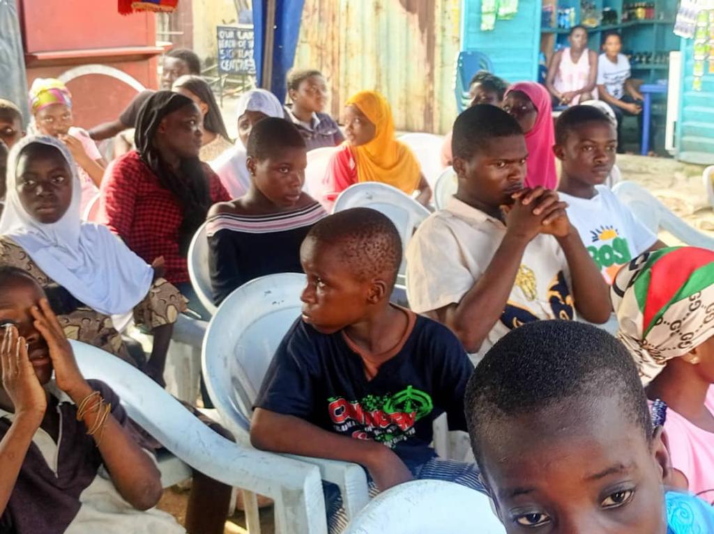 Children seated at a Kajola Foundation community event