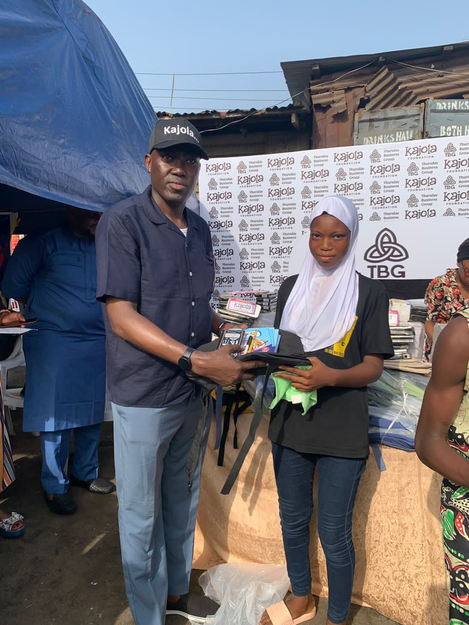TBG member presenting school supplies to a student in hijab