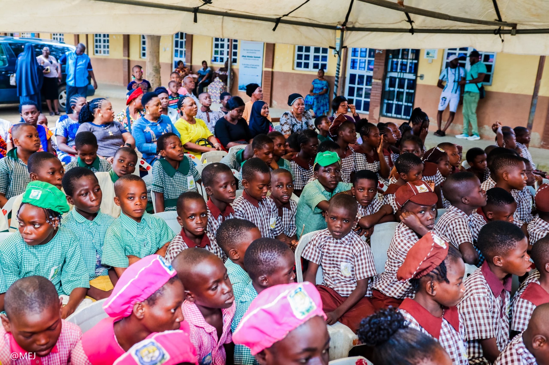 Hundreds of pupils and parents seated at a Kajola Foundation outreach