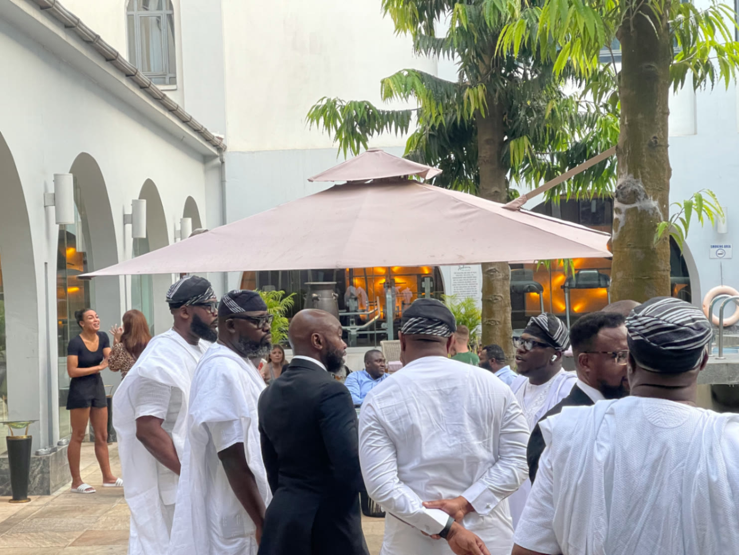 TBG members in white traditional attire gathered outdoors